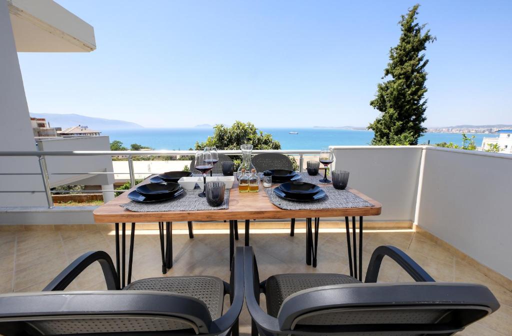 a table and chairs on a balcony with a view of the ocean at Villa Luisanna Free Parking in Vlorë