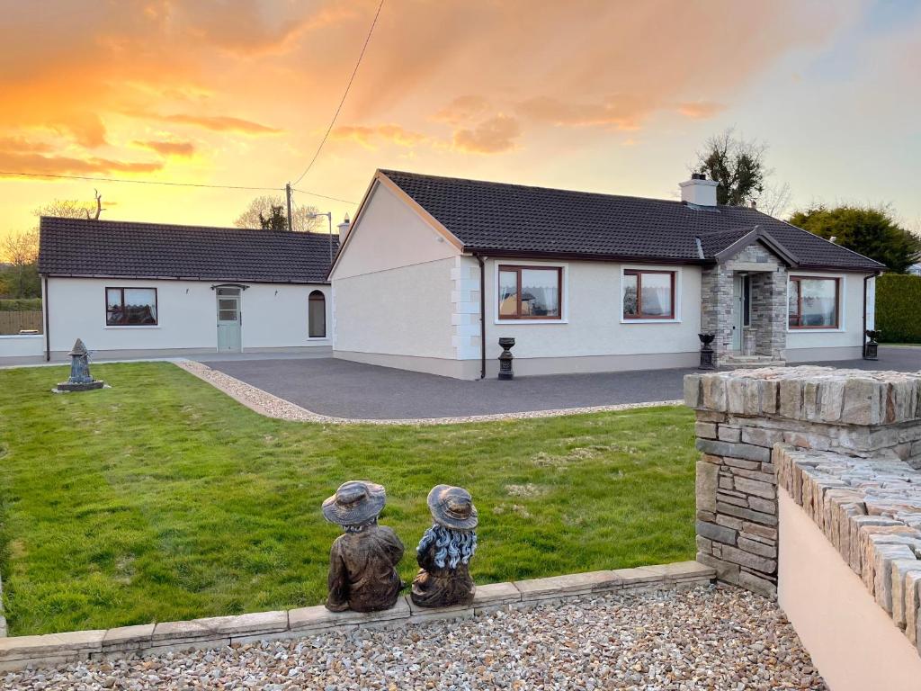 two statues sitting in the yard of a house at Steeple View B&B Guesthouse Donegal - Newly renovated in 2023 in Ballybofey