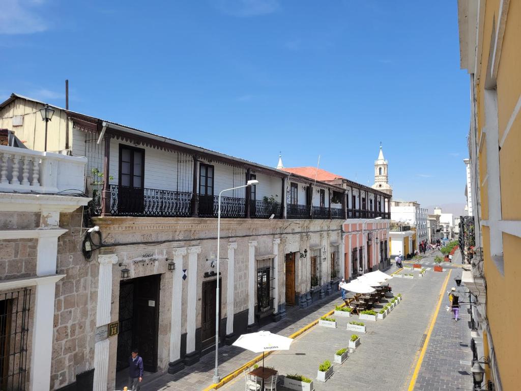 una calle con mesas y sombrillas en un edificio en Inka Roots Hostel en Arequipa