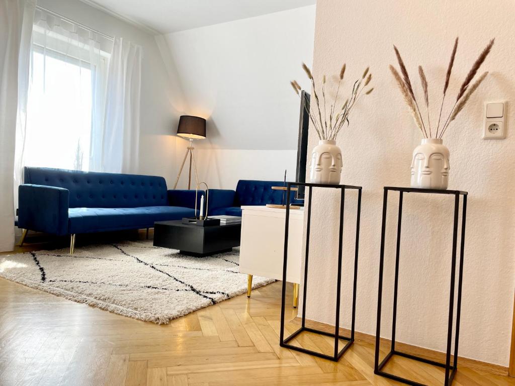 a living room with a blue couch and two vases at Design Maisonette I Kamin I 10 Personen I Netflix in Bremen