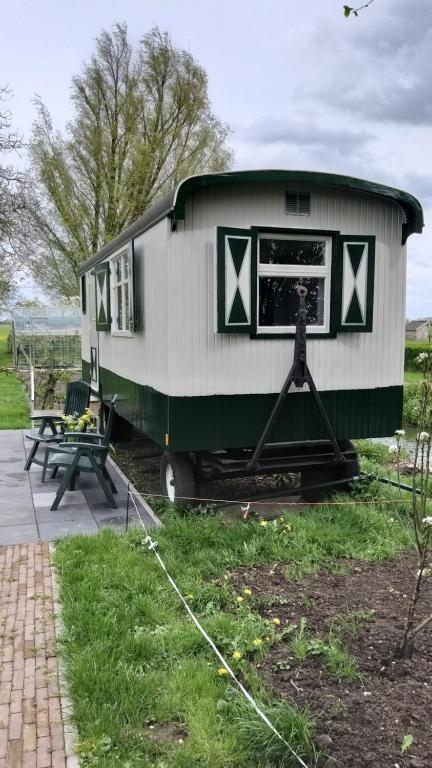 een trailer op het gras in een tuin bij Pipowagen ''Slapen by Co'' in Leerdam