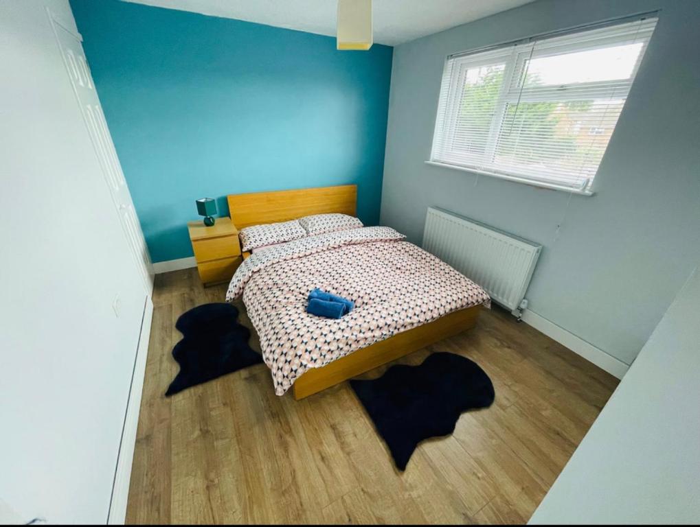 een slaapkamer met een bed met blauwe muren en houten vloeren bij Mia Property 2 in Bristol