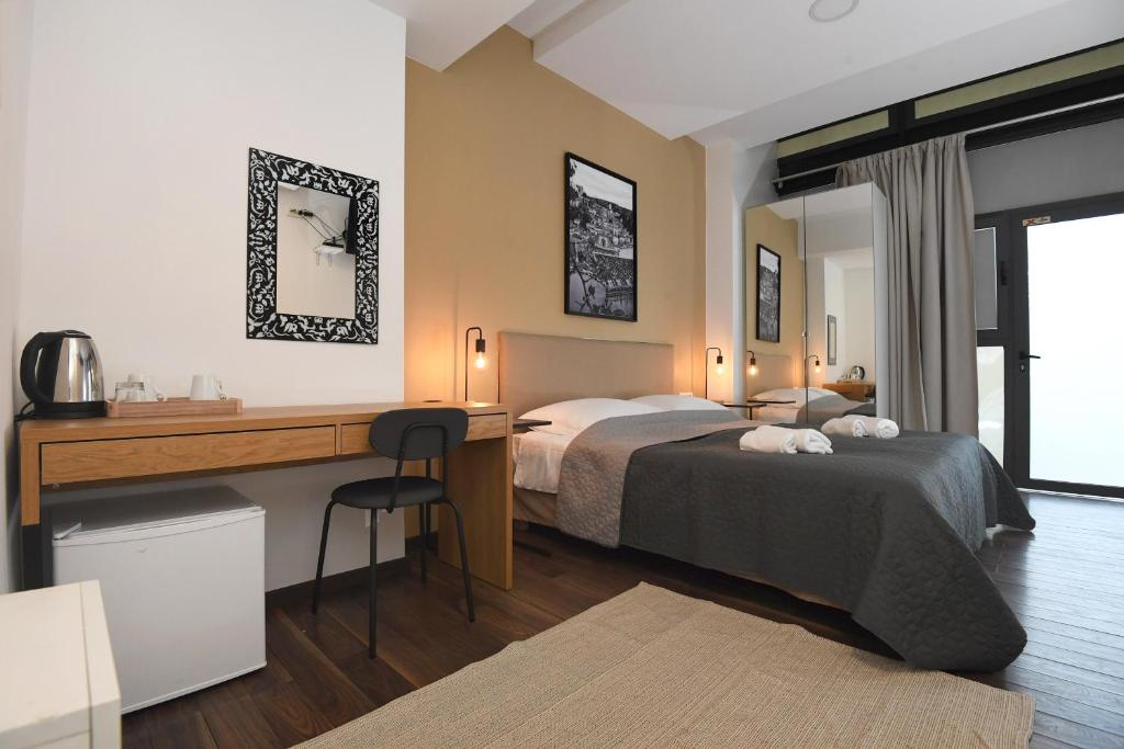 a hotel room with two beds and a desk and a desk at Il Padrino Rooms in Zadar