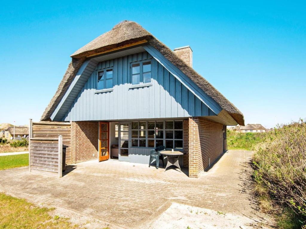 a house with a thatched roof with a patio at 7 person holiday home in Ulfborg-By Traum in Ulfborg