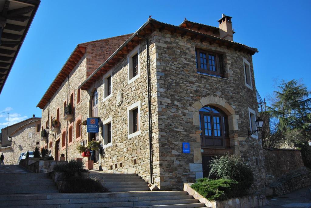 um edifício de pedra com escadas em frente em La Lechería em Val de San Lorenzo
