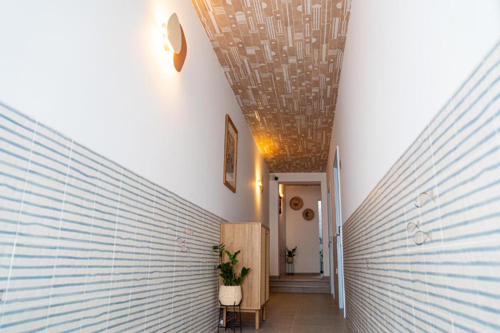 a hallway with a white wall and a ceiling at Hostal Tarantelo Conil in Conil de la Frontera