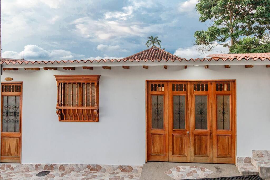 a white house with wooden doors and windows at Casa Centro Guaduas in Guaduas