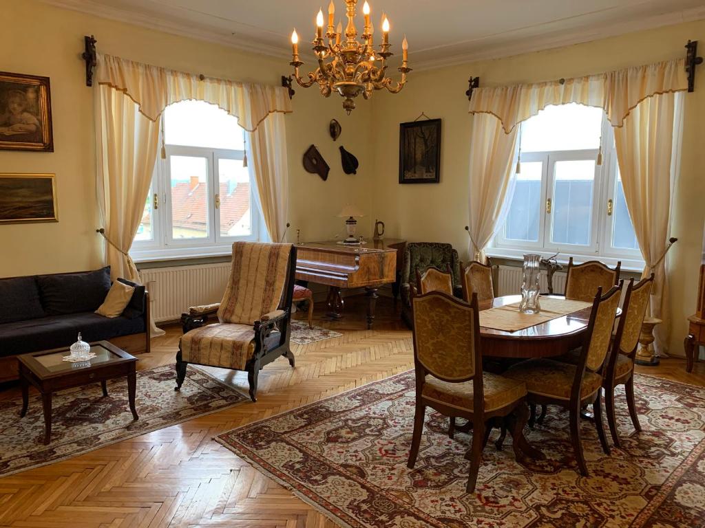 sala de estar con mesa y piano en The Marchburg Apartment, en Maribor
