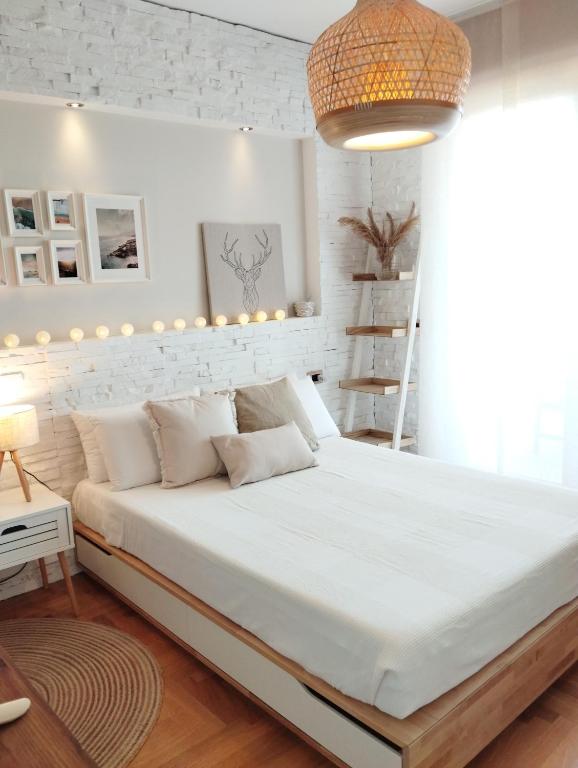 a bedroom with a large white bed with a white brick wall at Natural Charm Apartment in Rome