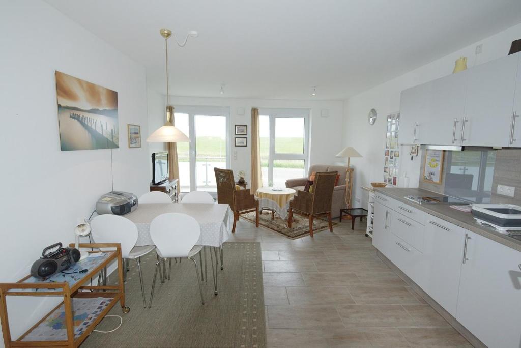 a kitchen and living room with a table and chairs at de Rootbost in Neufeld
