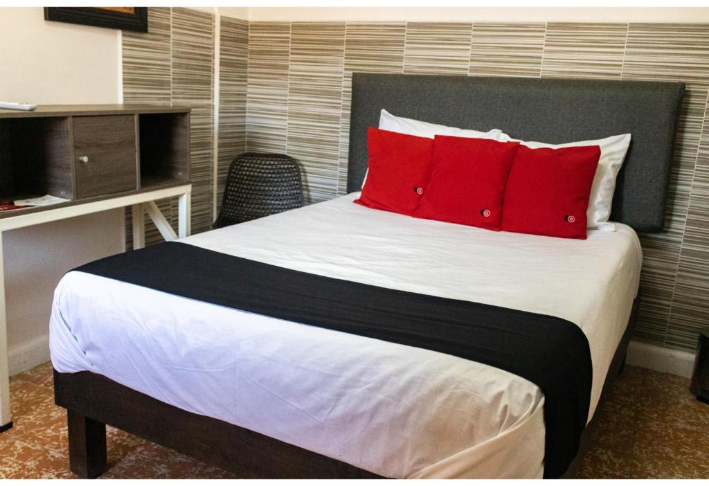 a bedroom with a large bed with red pillows at Hotel La Colección, Universidad de Guanajuato, Centro in Guanajuato