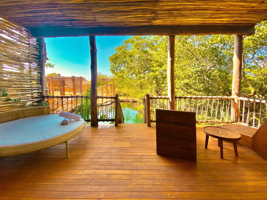 a room with a bath tub on a deck at Hotel Shibari - Restaurant & Cenote Club in Tulum