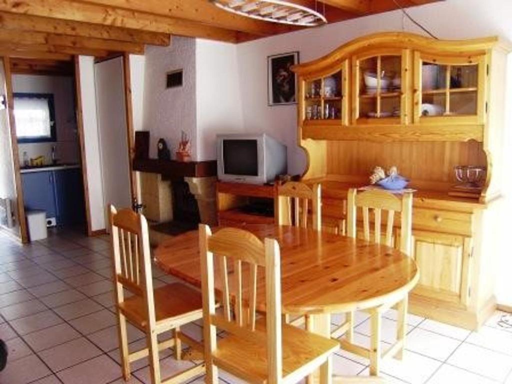une salle à manger avec une table et des chaises en bois dans l'établissement Appartement T3 chaleureux, 7 pers, cheminée, animaux admis, WiFi, proche commerces - FR-1-402-87, à Esquièze - Sère