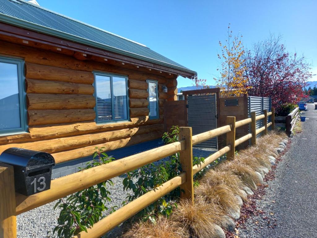 une clôture en bois devant une cabane en rondins dans l'établissement The Cabin, à Twizel