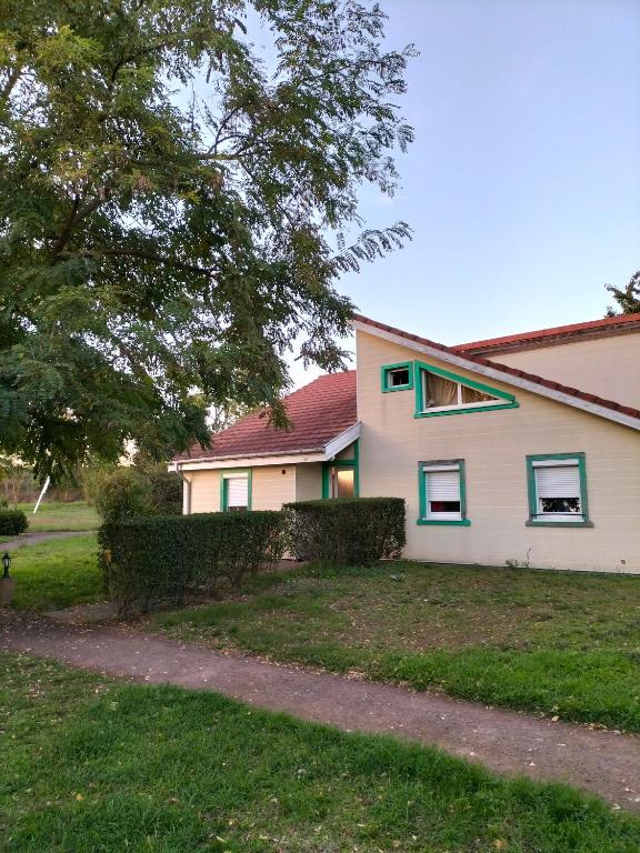 une maison avec une haie devant elle dans l'établissement Appart'Hôtel Les ACACIAS courte et longue durée, à Bischoffsheim