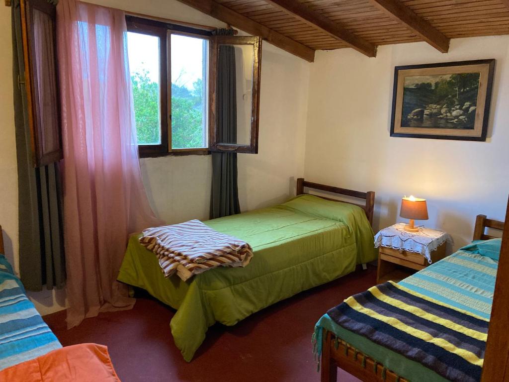 een slaapkamer met 2 aparte bedden en een raam bij LA SERENA in Aguas Dulces