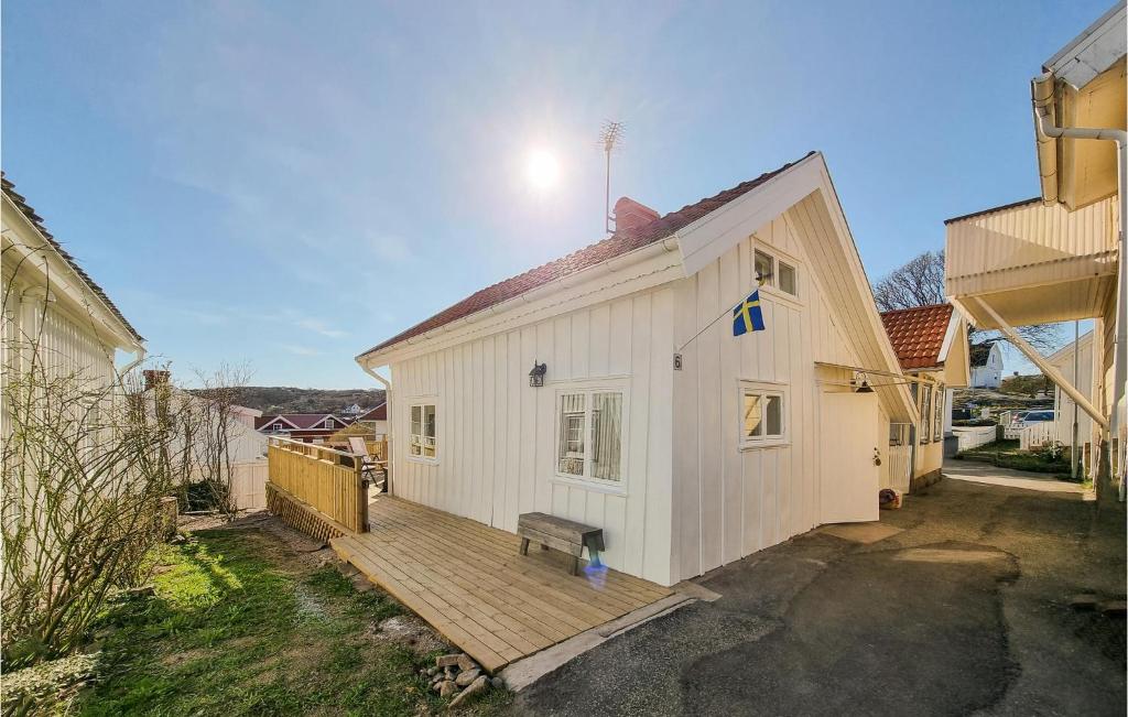 een wit huis met een houten terras in een tuin bij Stunning Home In Hovenset With 3 Bedrooms in Hovenäset