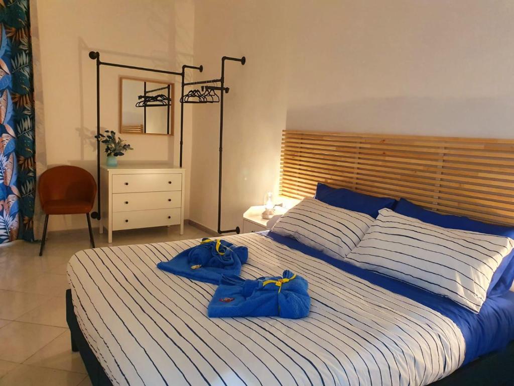Casa Miracoli 40 في نابولي: غرفة نوم بها سرير كبير وعليها أكياس زرقاء