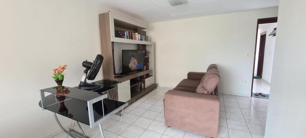 sala de estar con sofá y TV en Residencial Mar de Gênova - Bessa, en João Pessoa