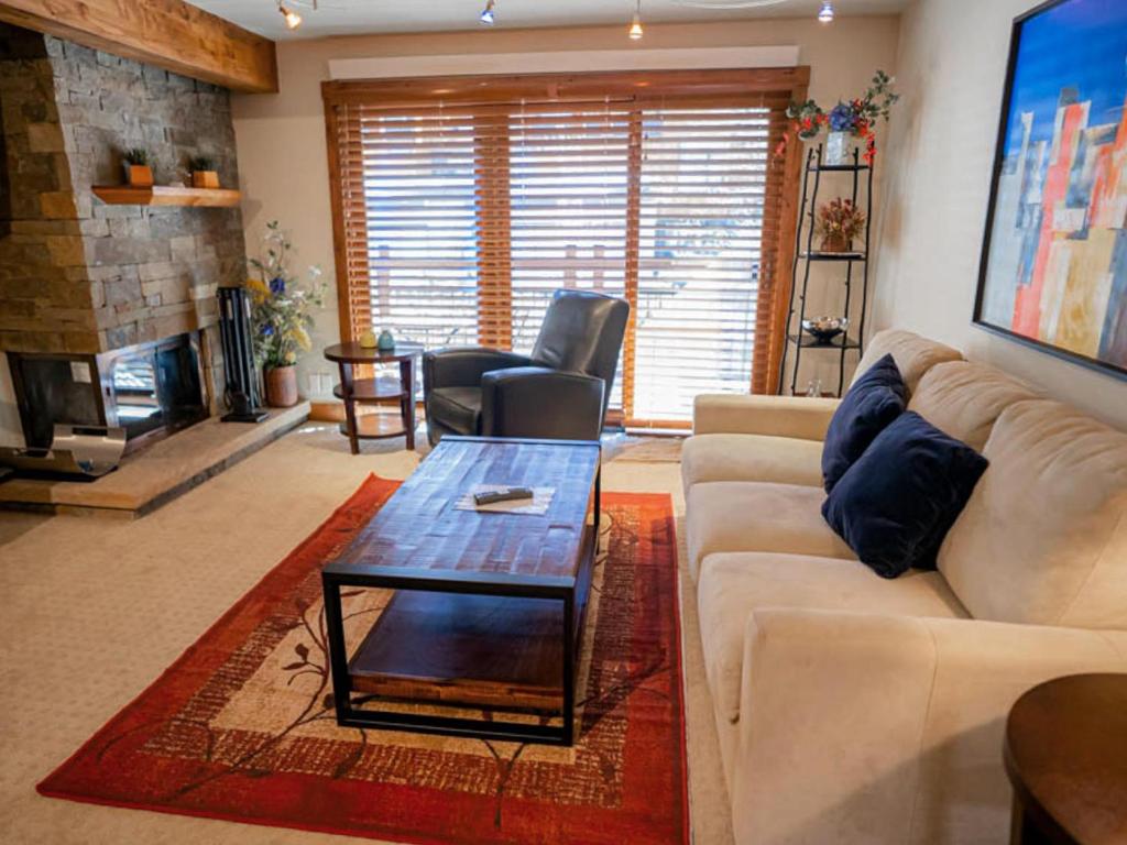 uma sala de estar com um sofá e uma mesa de centro em Lift One - Updated Cozy Top Floor Two-bedroom With Mountain View em Aspen