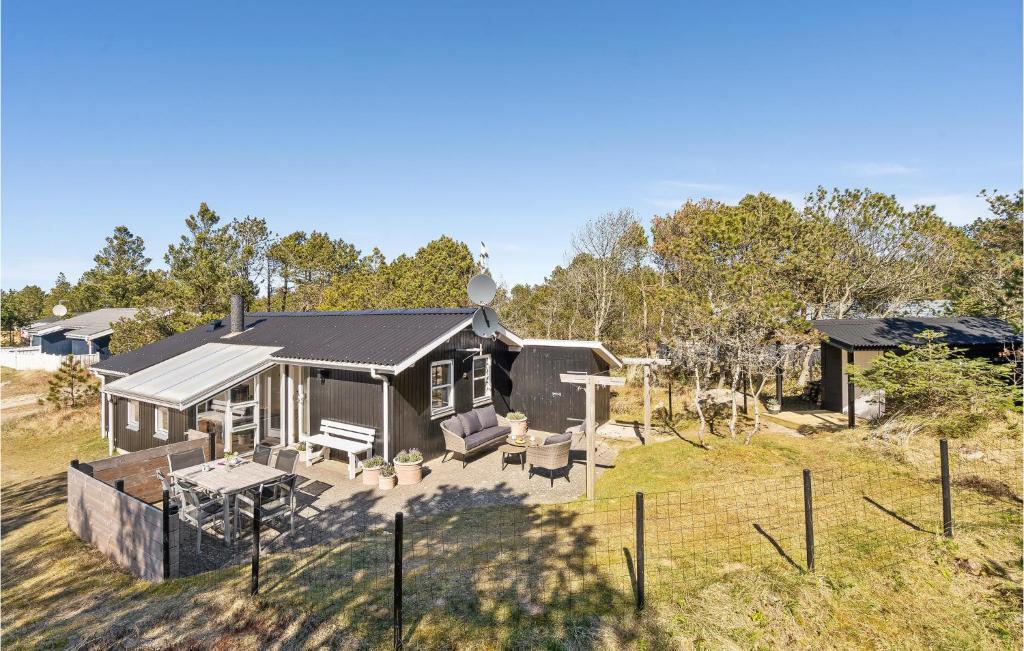 a black house with a fence in a yard at Beautiful Home In Thisted With 2 Bedrooms And Wifi in Nørre Vorupør