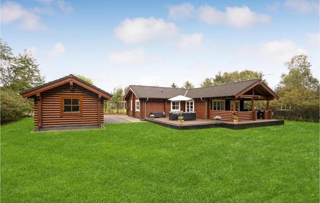 una cabaña de madera en un patio con césped verde en 3 Bedroom Amazing Home In Fars en Hvalpsund