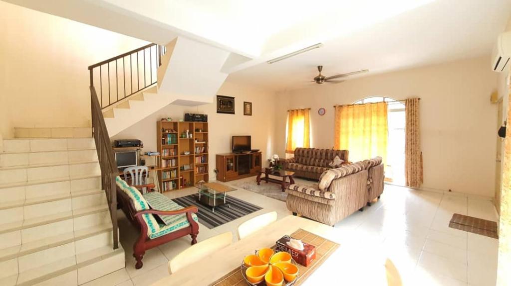 a living room with a couch and a staircase at Vision Homestay in Seremban