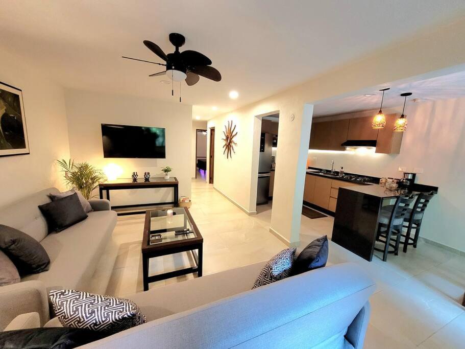 uma grande sala de estar com um sofá e uma mesa em Departamento Céntrico y Moderno en Cancún. em Cancún