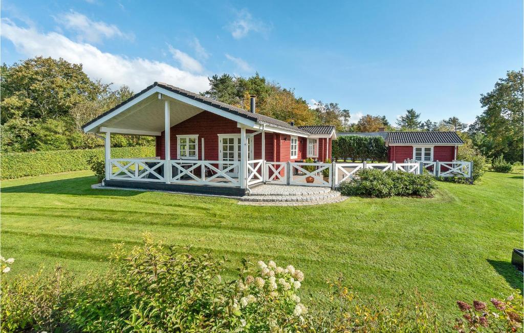 una casa roja con un gran patio delante en Gorgeous Home In Fars With Kitchen, en Ertebølle