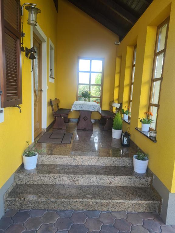 a yellow room with a table and some stairs at Ferienwohnung Lückl in Mettersdorf am Saßbach