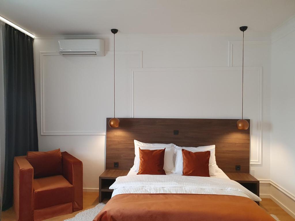 a bedroom with a large bed and a chair at Accommodation Iva in Zadar