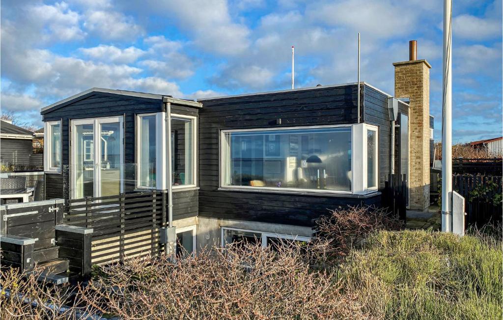 una casa negra con grandes ventanas en un campo en Nice Home In Esbjerg V With Wifi, en Esbjerg