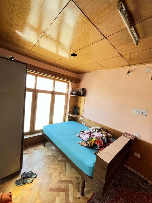 Habitación con cama y banco. en Napishu Summer Home, en Leh