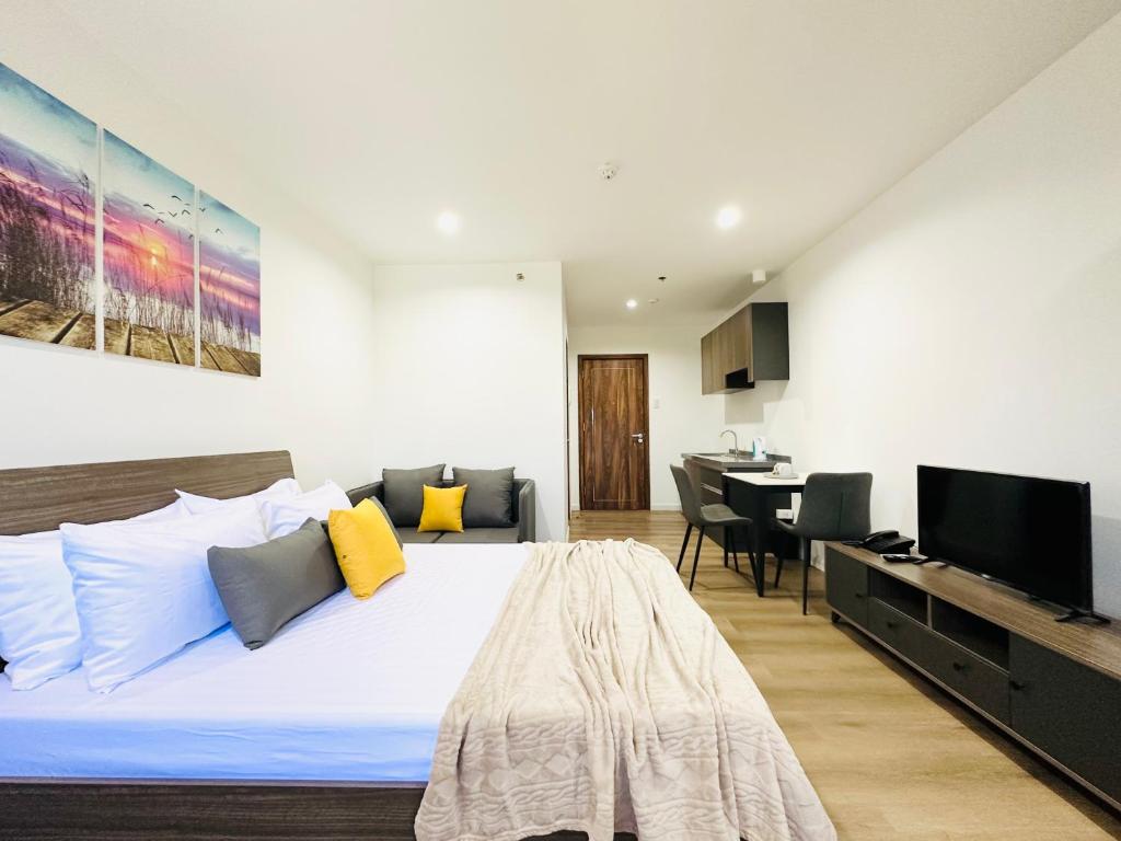 1 dormitorio con 1 cama grande y TV en Furnished Rentals at Mangrove Residences Mactan, en Punta Engaño
