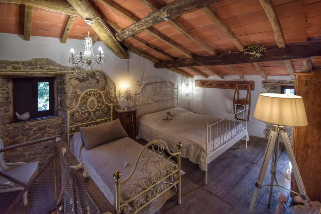 a bedroom with a bed and a couch and a lamp at La casina del prete in Caprese Michelangelo