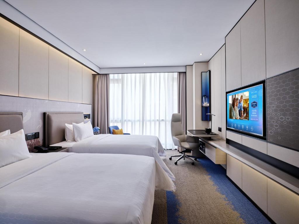 Postel nebo postele na pokoji v ubytování Hampton by Hilton Shenzhen North Station