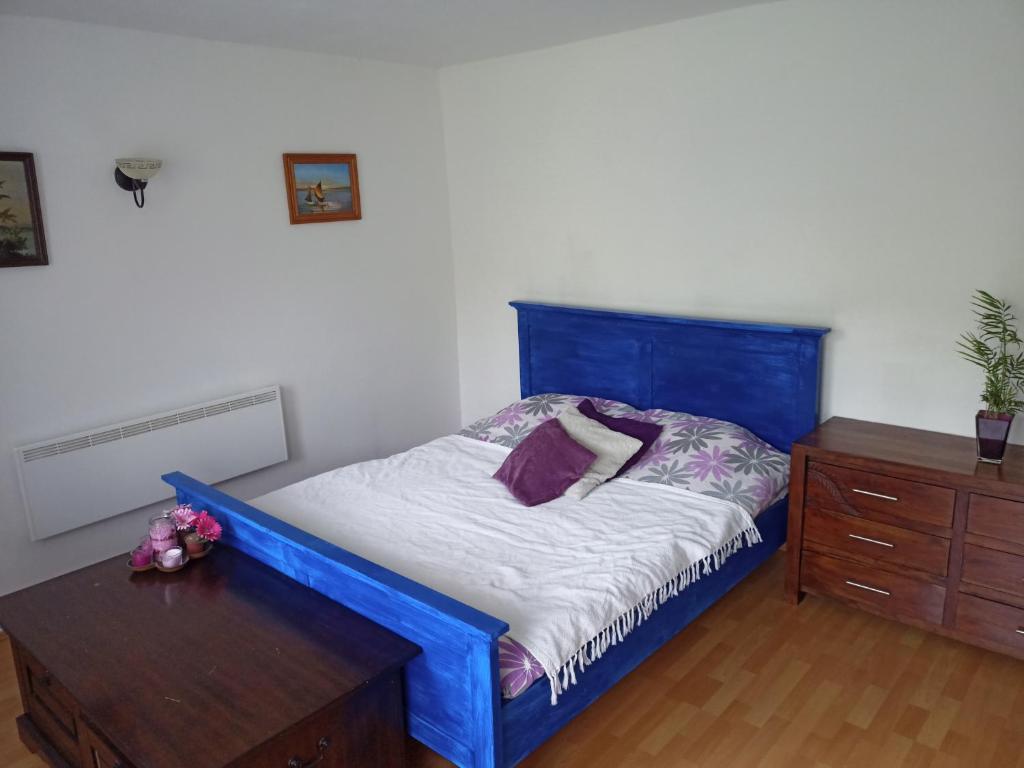 1 dormitorio con cama azul y tocador de madera en Nice Apartment near by Capital of Slovenia en Liubliana