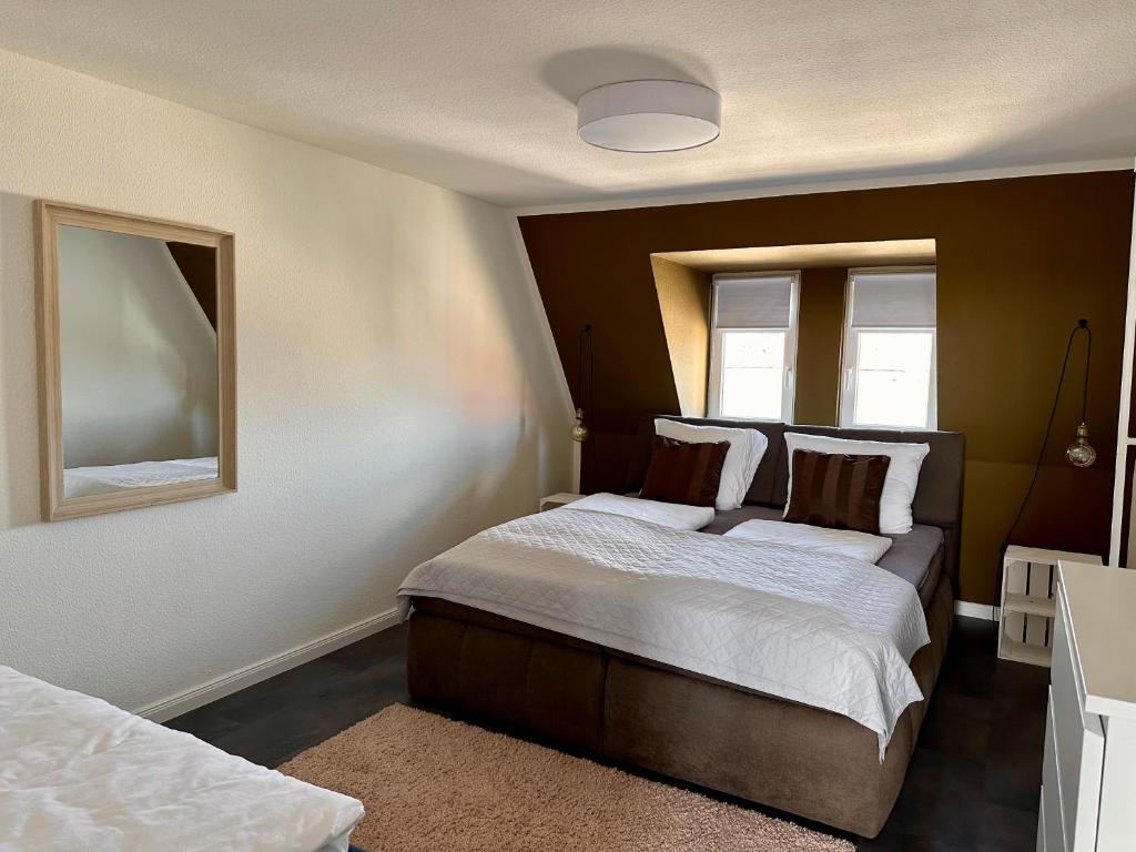 1 dormitorio con 2 camas y espejo en Geschmackvolle Ferienwohnung in Markkleeberg, en Markkleeberg