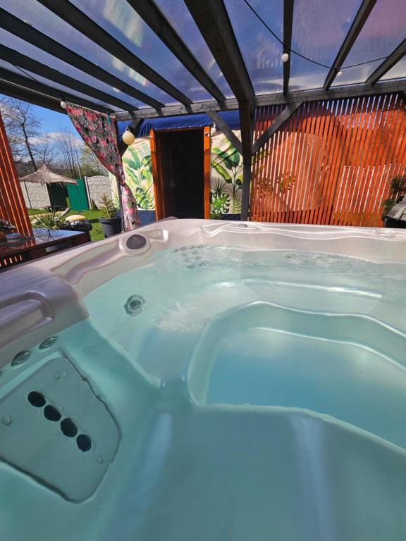 Zagórnik的住宿－Aloha Glamp - Domki z prywatnym jacuzzi & balia & sauna，凉棚下按摩浴缸