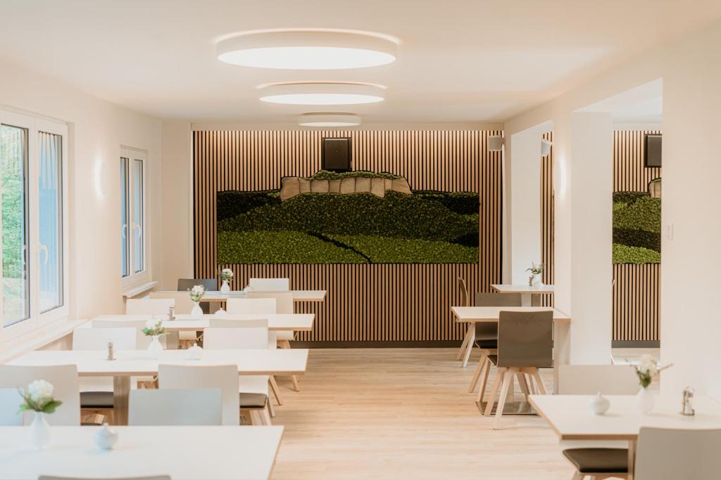 a restaurant with white tables and white chairs at Bergpension Laasen Perle Rathen in Kurort Rathen