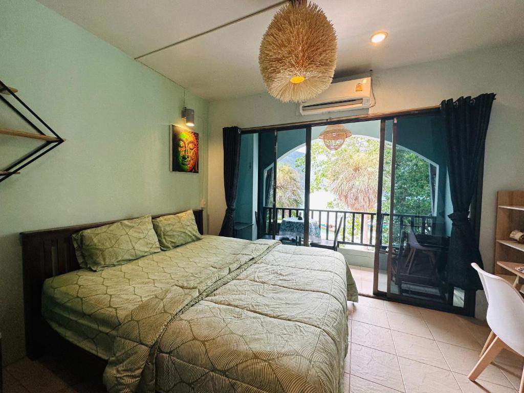 a bedroom with a bed and a large window at MILD ROOM SEA VIEW ROOM FOR RENT in Phi Phi Don