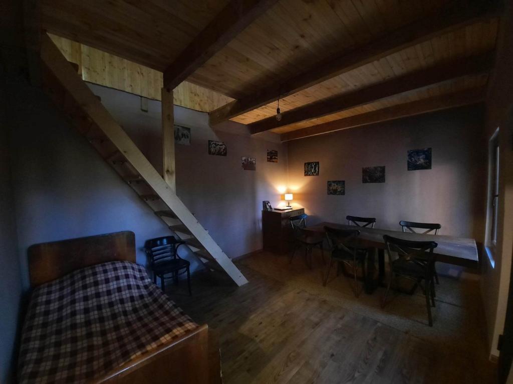 sala de estar con mesa y sillas y escalera en Dali Guest House, en Oni