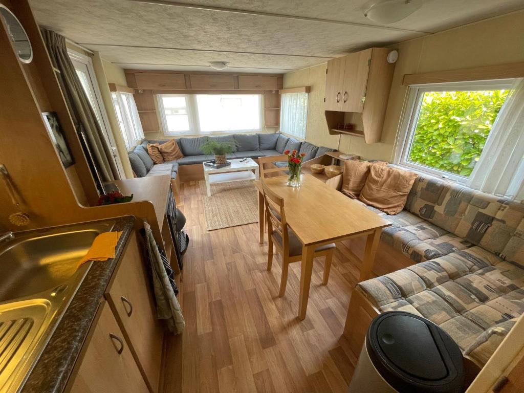 een woonkamer met een tafel en een bank bij Forest Feelings - op 5 sterren park met heerlijke privé tuin in Beekbergen