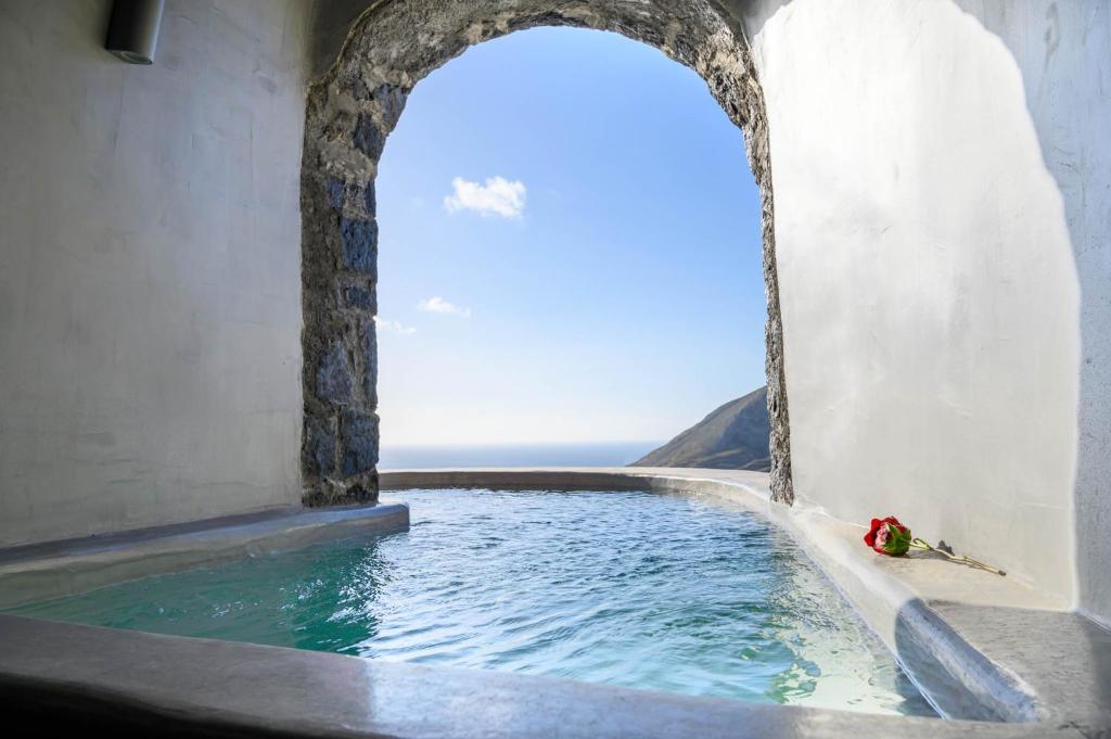 a plunge pool in a building with a view of the ocean at Deep Earth Villas in Éxo Goniá