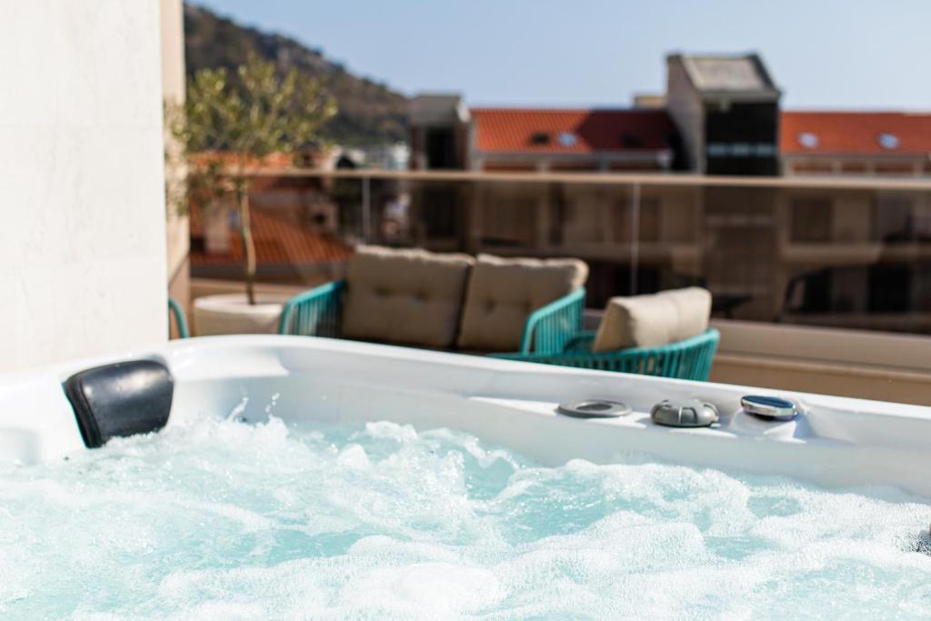 a jacuzzi tub on a balcony with chairs at Garni Hotel Casa di Sofia in Budva