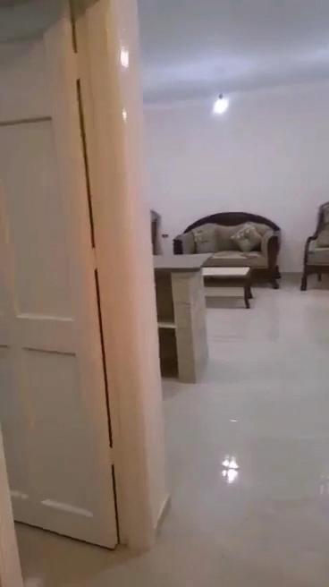 um quarto branco com uma porta e um sofá em القاهره em El-Sa`âida