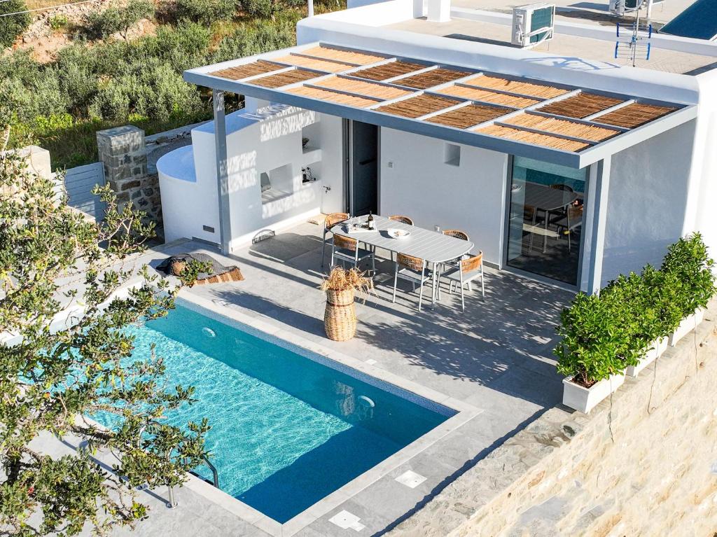 a house with a swimming pool and a fire hydrant at Santa Marina Syros in Liaropá