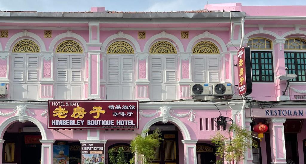 un edificio rosa con un cartello davanti di Kimberley Boutique Hotel a George Town