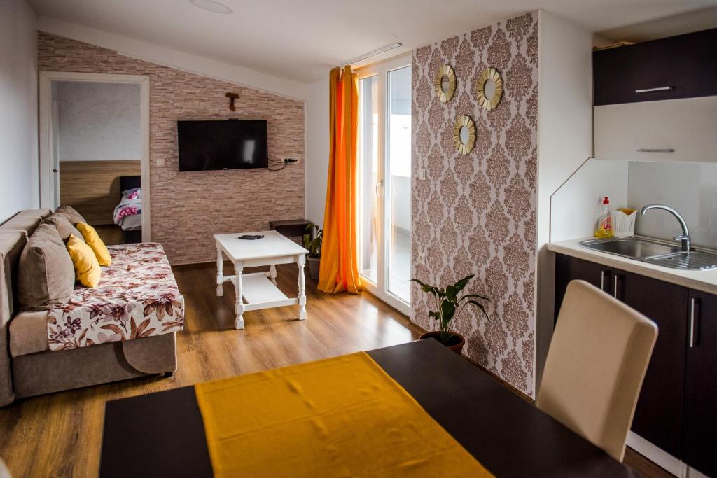 cocina y sala de estar con sofá y mesa en Apartments Joja, en Međugorje