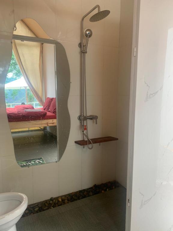 a bathroom with a shower and a mirror at Retro Khe Sanh in Lao Bao
